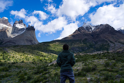 Rear view of man on mountain against sky