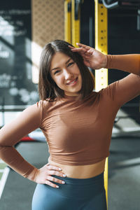 Portrait of young brunette woman in sport active wear in fitness club gym