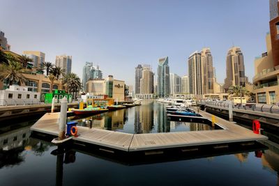 Boats moored in river against buildings in city