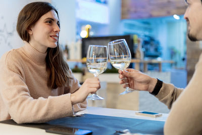 Couple holding glass of drink on table