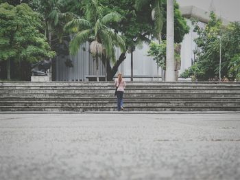 Full length of woman standing on steps