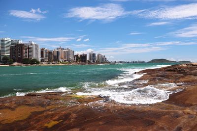 Scenic view of sea and buildings against sky