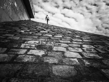 Low angle view of woman on wall against building