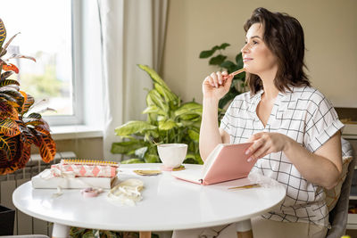 Young woman using mobile phone on table