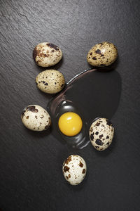 Quail eggs on a black table.