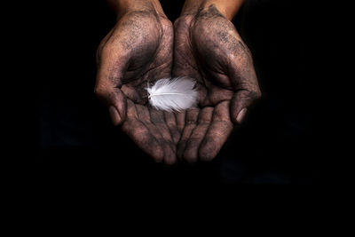 Close-up of human hand against black background