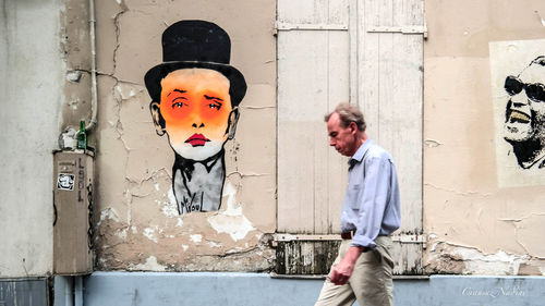 Man standing against graffiti wall