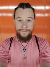 Portrait of young man standing against wall