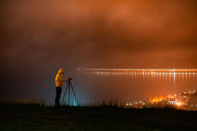 Man photographing against sky during sunset