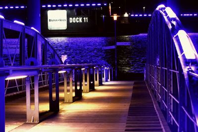 Illuminated bridge over sea at night