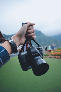 Midsection of man photographing camera