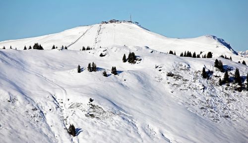 Group of people on snowcapped mountain against sky