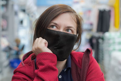 Portrait of young woman holding camera outdoors