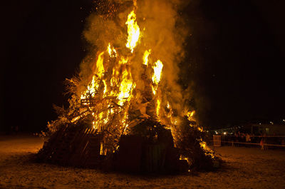 Bonfire against trees at night