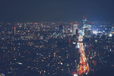 Illuminated cityscape against sky at night