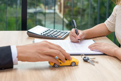 Midsection of man using mobile phone on table