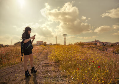 Woman standing on field against sky