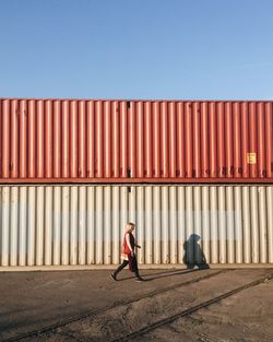 Full length of woman with umbrella against clear sky