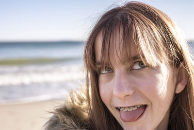 Close-up portrait of smiling young woman at beach