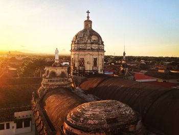 Old church in city against sky during sunset