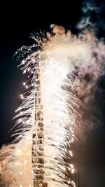 Low angle view of firework display at night