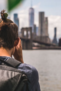 Close-up of man against river in city