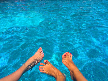 Low section of two women in swimming pool