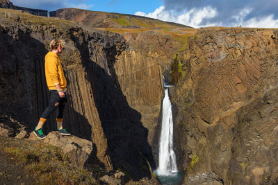 Panoramic view of man surfing on rock against sky