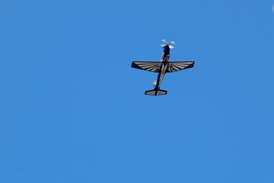 Low angle view of weather vane against clear blue sky