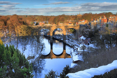 Arch bridge over river against sky