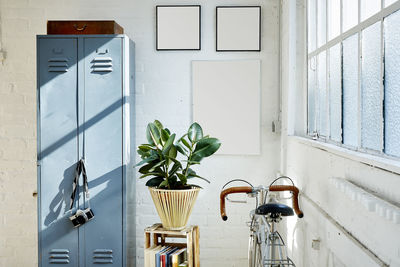 Bicycle by locker against wall at home