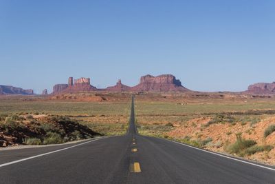 Road amidst landscape against clear blue sky