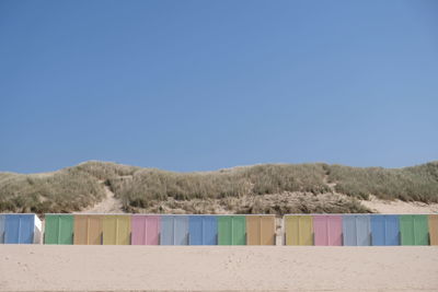 Multi colored umbrellas on beach against clear blue sky