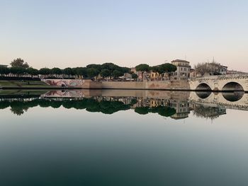 Arch bridge over lake against clear sky