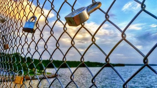 Chainlink fence against cloudy sky