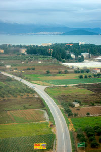 High angle view of road amidst field against sky