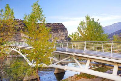 Footbridge over lake against sky