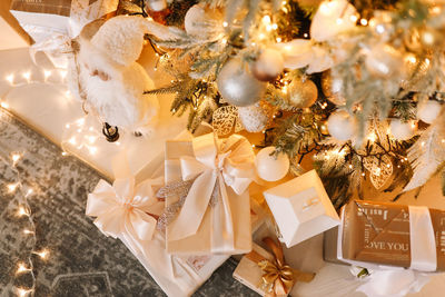 Christmas concept. gift boxes and toys lie at the christmas tree decorated with a garland at home. 