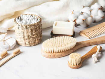 Zero waste personal bathroom accessories. wooden brush, soap, toothbrush, towel on marble background