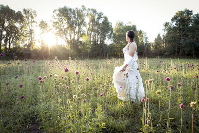 Rear view of woman standing on field