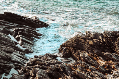 Aerial view of sea waves splashing on rocks