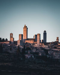 Buildings in city against clear sky