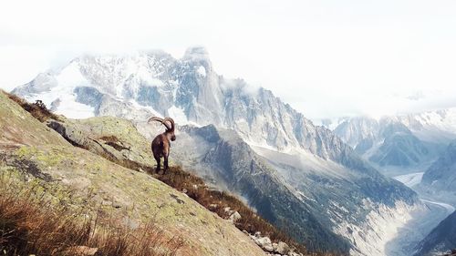 Full length of person on snowcapped mountains against sky