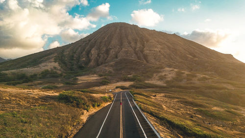 Panoramic view of road leading towards mountains against sky