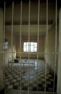 Bed on checked patterned floor at prison cell