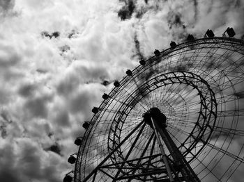 Low angle view of ferris wheel against cloudy sky