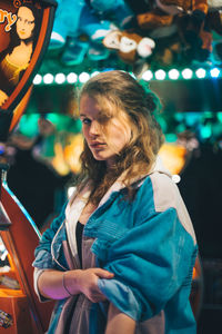 Young woman standing at illuminated night