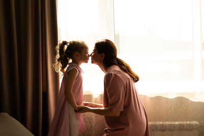 Close-up of mother and daughter exchanging loving whispers and giggles. illustration of  happiness