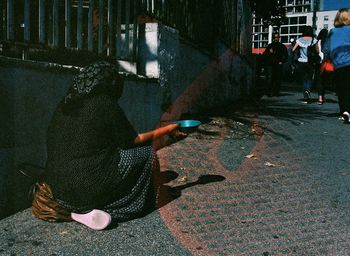 People sitting on street in city