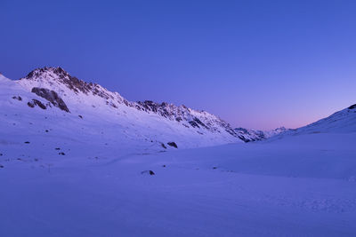 Scenic view of snowcapped mountains against clear blue sky